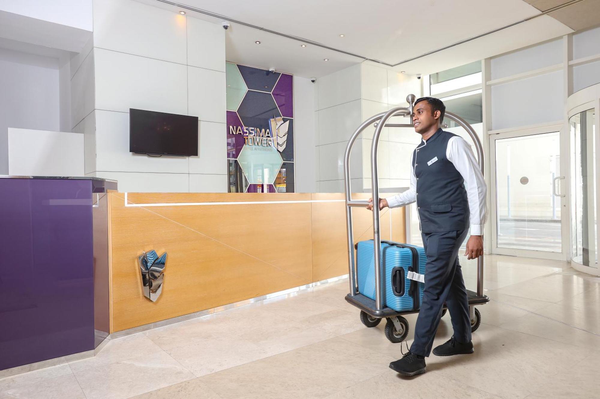 Nassima Tower Hotel Apartments Dubai Exterior photo A bellboy pushing a luggage cart